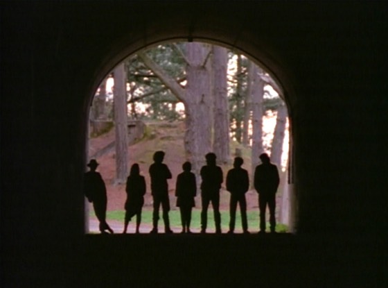 Seven silhouettes in a stone archway